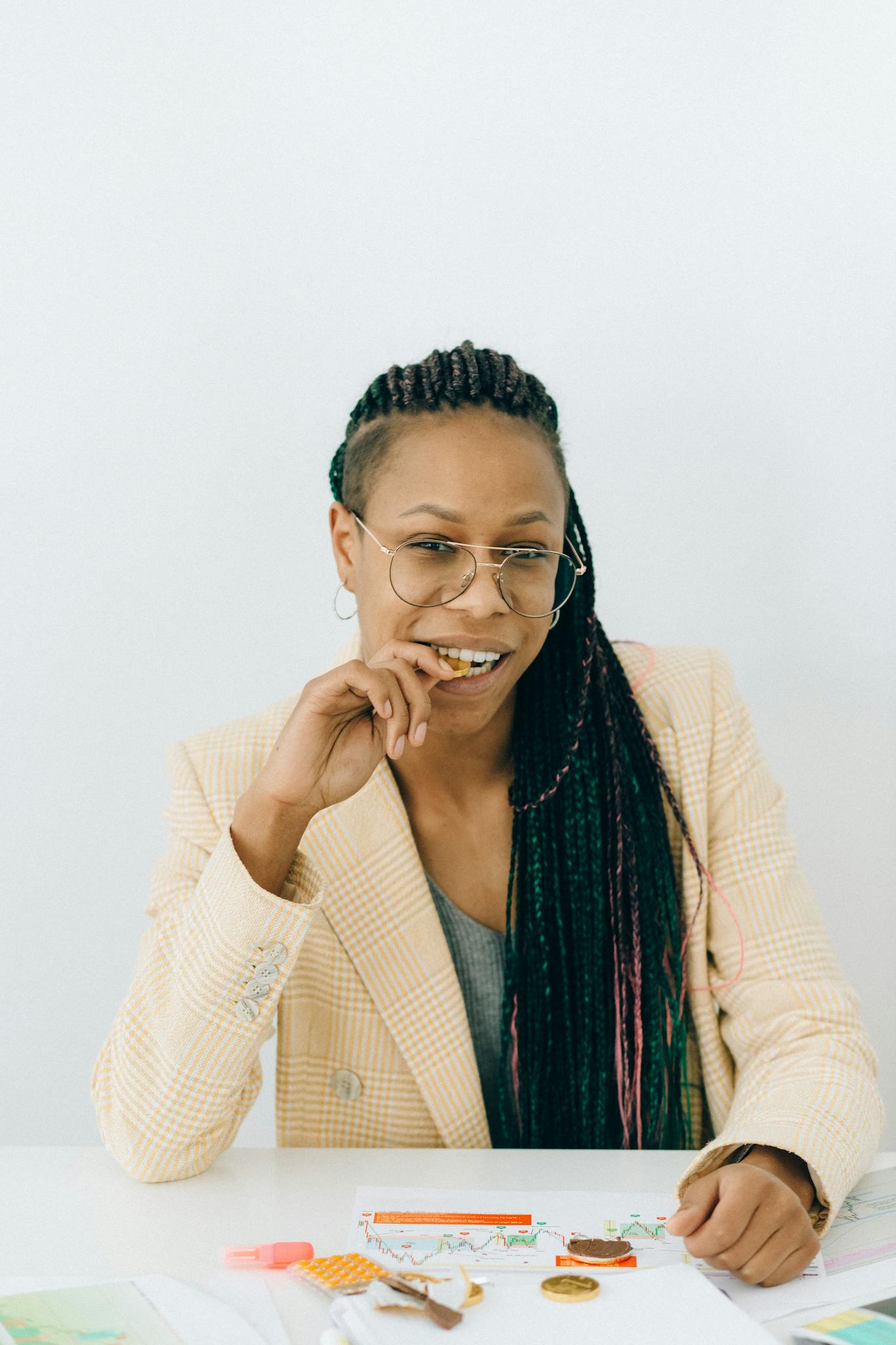 Focused businesswoman analyzing financial data at a white table, exuding professionalism and confidence.